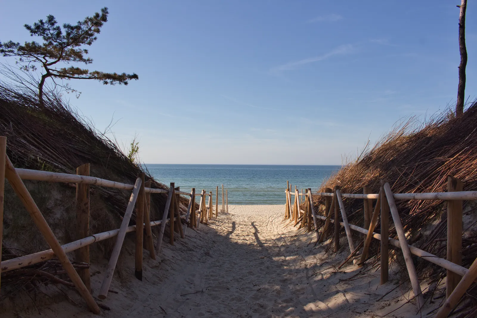Wejście na plażę w Krynicy Morskiej, po prawej i lewej stronie wydma, w centrum polski Bałtyk